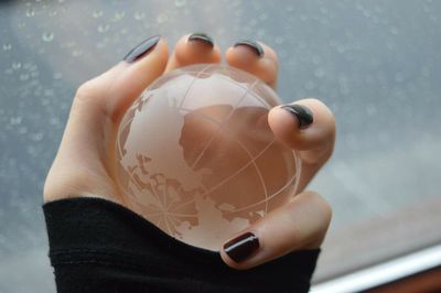 Close-up of hand holding glass sphere 