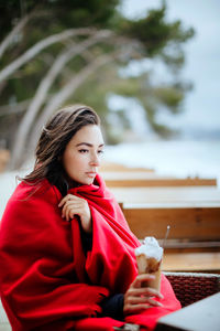 Close-up of young woman with ice creams outdoors
