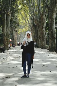 Woman standing on tree trunk in forest