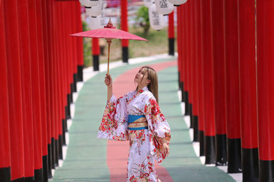 Woman standing by red outside temple