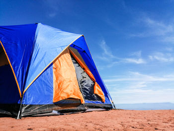 Tent on beach against blue sky