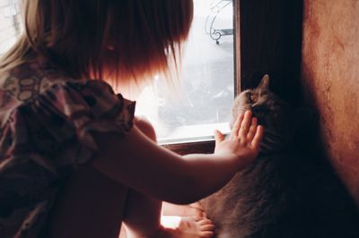 Midsection of woman with cat at home