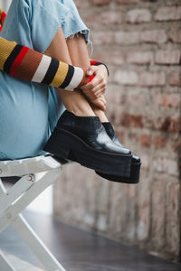 Low section of woman sitting on wall