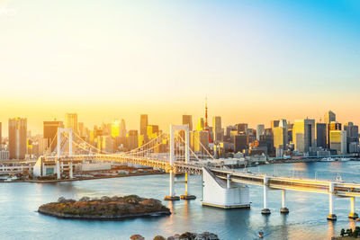 View of bridge over river in city during sunset