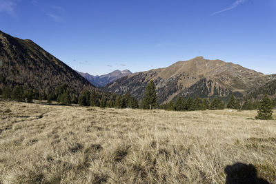 Scenic view of landscape and mountains against blue sky