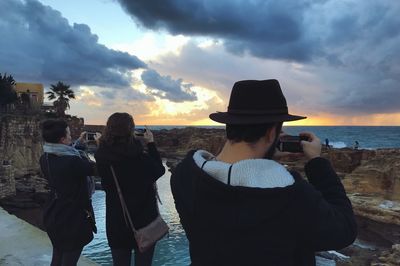 People at observation point against sky during sunset