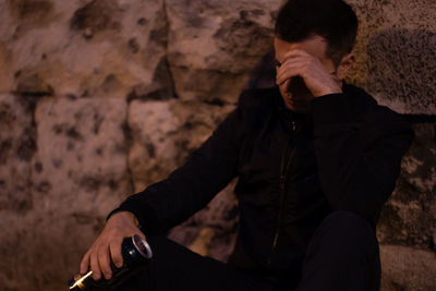 Young man sitting on rock