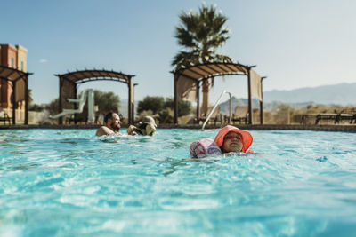 Young preschool age girl swimming in pool on vacation in palm springs