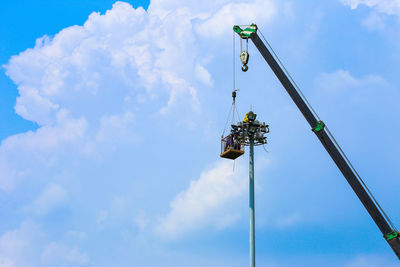 Low angle view of crane against sky
