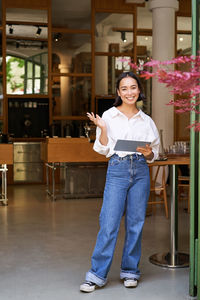 Portrait of smiling young woman standing in city