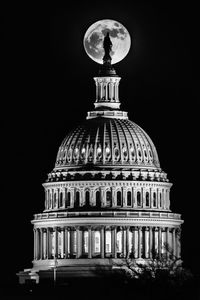 Low angle view of illuminated building against sky at night