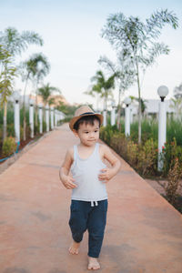 Portrait of boy on footpath against trees