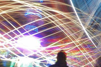 Low angle view of illuminated woman in dark room