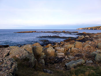 Rocks at shore against sky