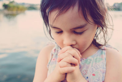 Close-up of cute girl praying