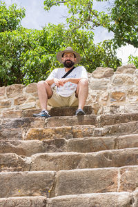 Low angle portrait of mature man sitting on steps