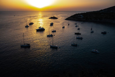 High angle view of people at beach against sky during sunset