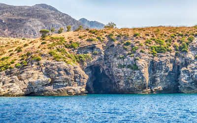 Scenic view of rock formation by sea against sky