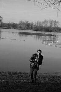 Man standing by lake against sky