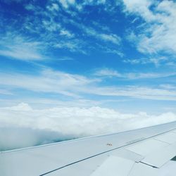 Airplane wing against cloudy sky