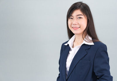 Portrait of a smiling young woman against white background