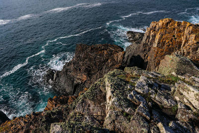 High angle view of rocky mountains at sea shore