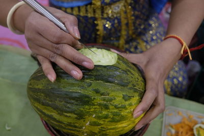 Cropped hands of woman carving on food