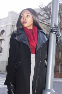 Portrait of beautiful young woman standing against built structure