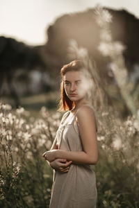 Happy woman standing against plants