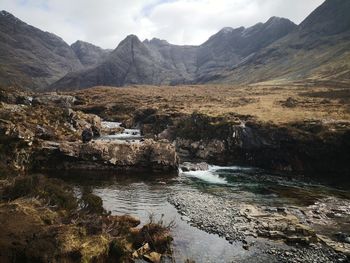 Scenic view of river amidst mountains against sky