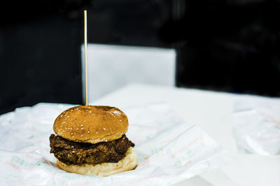 Close-up of hamburger with onion ring against black background