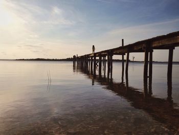 Pier on sea against sky at sunset