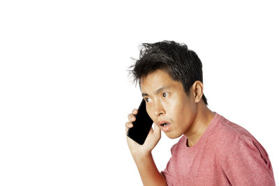 Portrait of young man looking away against white background