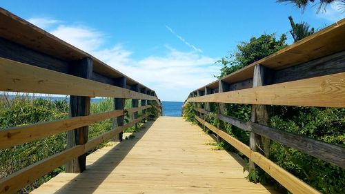 Pier leading towards jetty against sky