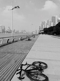 Bicycle parked on street by buildings against sky