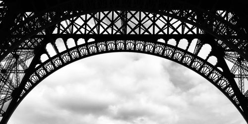 Low angle view of arch bridge against cloudy sky