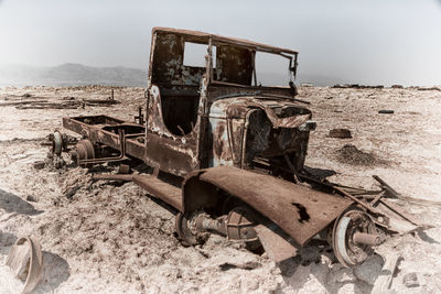 Old abandoned truck on land against sky