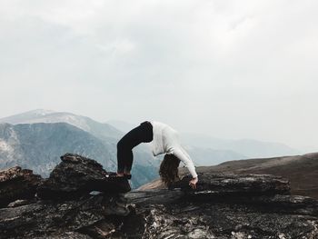 Woman standing on mountain against sky