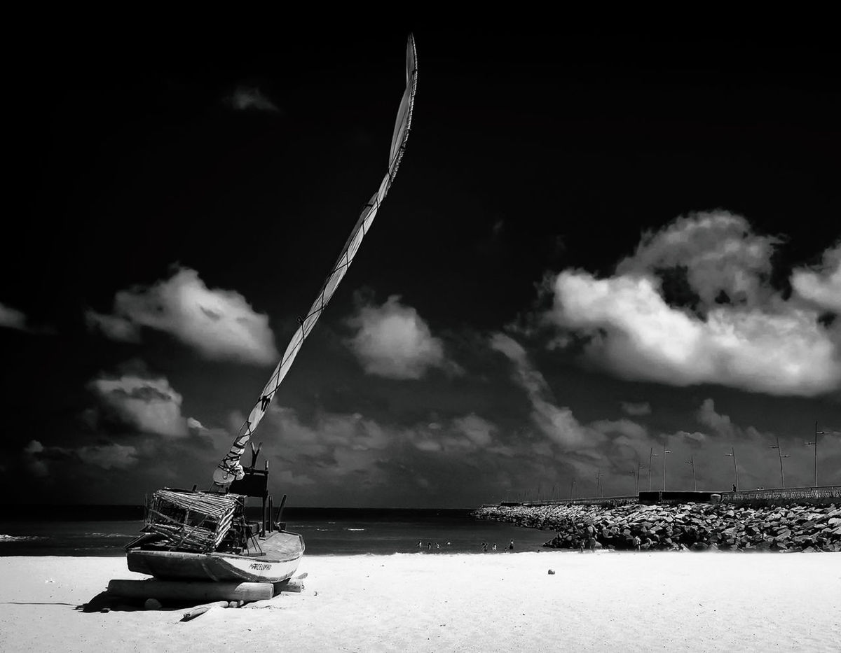 CRANE IN SEA AGAINST SKY