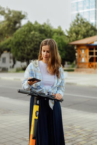 Portrait of smiling young woman standing in city
