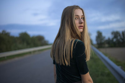 Woman walking on the road looking back