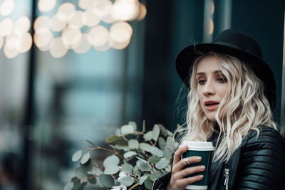 Portrait of young woman drinking outdoors