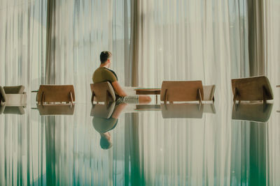 Man sitting on chair in restaurant