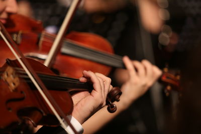 Midsection of man playing guitar at music concert