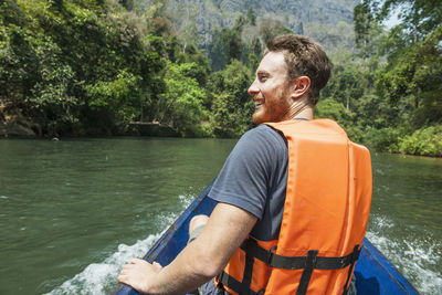 Man looking at river against trees