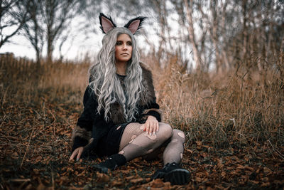 Young woman standing against tree during autumn