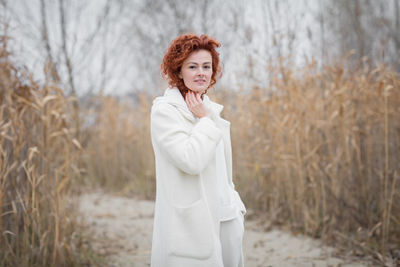 Attractive stylish woman holding dry reed walking in park