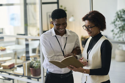 Smiling businessman and businesswoman discussing work in office