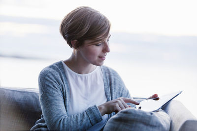 Young woman looking down while sitting outdoors