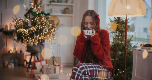 Portrait of woman holding christmas tree